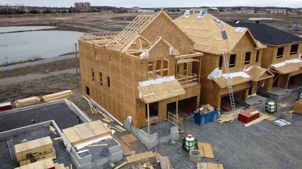 Aerial drone photo of a house under construction, framing stage